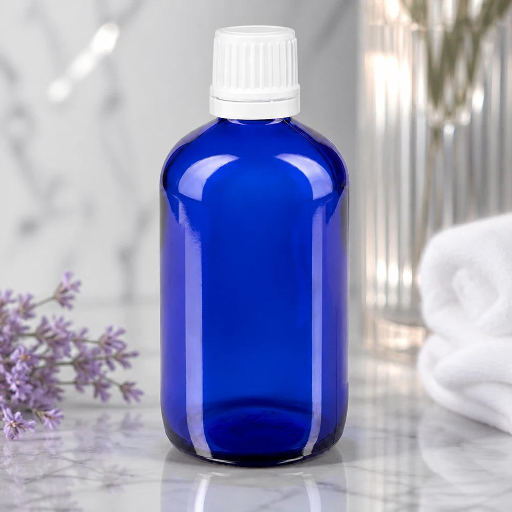 Blauwe glazen flessen 20ml met wit druppelsluiting kinderslot St Blauw druppelglas van 20 ml met UV-bescherming en een witte veiligheidsdop op marmer