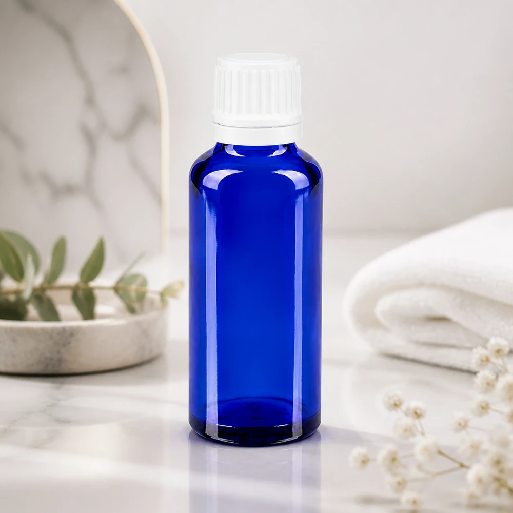 Slanke blauwe druppelfles van 30 ml, vervaardigd uit hoogwaardig ApoGlas, met een nauwkeurig doseerinzetstuk van 0,7 mm