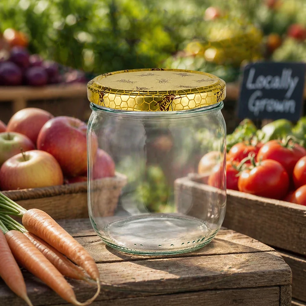 Honingpot 500 g met deksel met honingraatmotief BasicSeal UNiTWIST Lege honingpot van 500 g met honingraatdeksel op een houten plank tussen verse groenten van de boerenmarkt