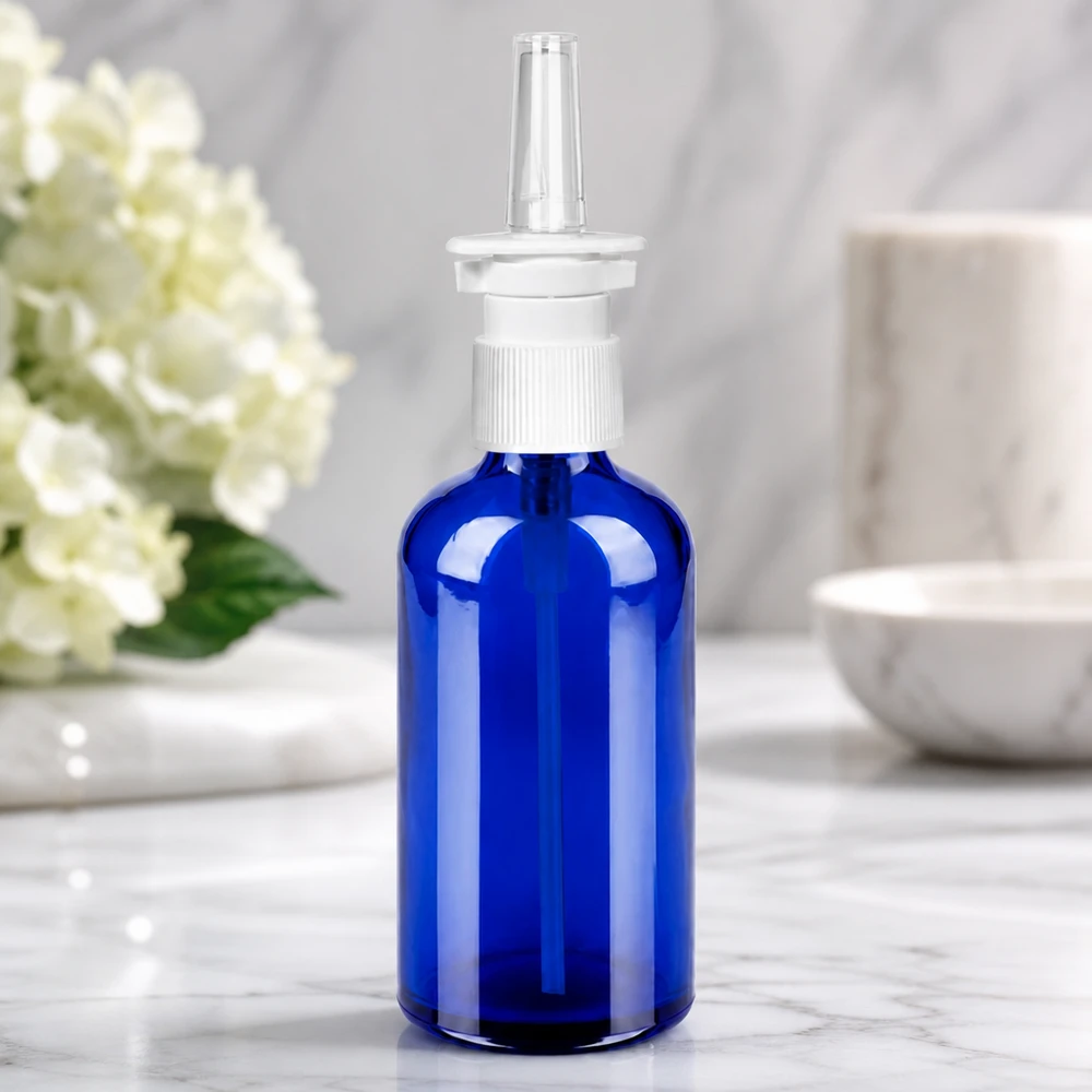Leeg 100ml neussprayflesje van blauw glas met wit verstuivingshulpstuk voor zelf vullen