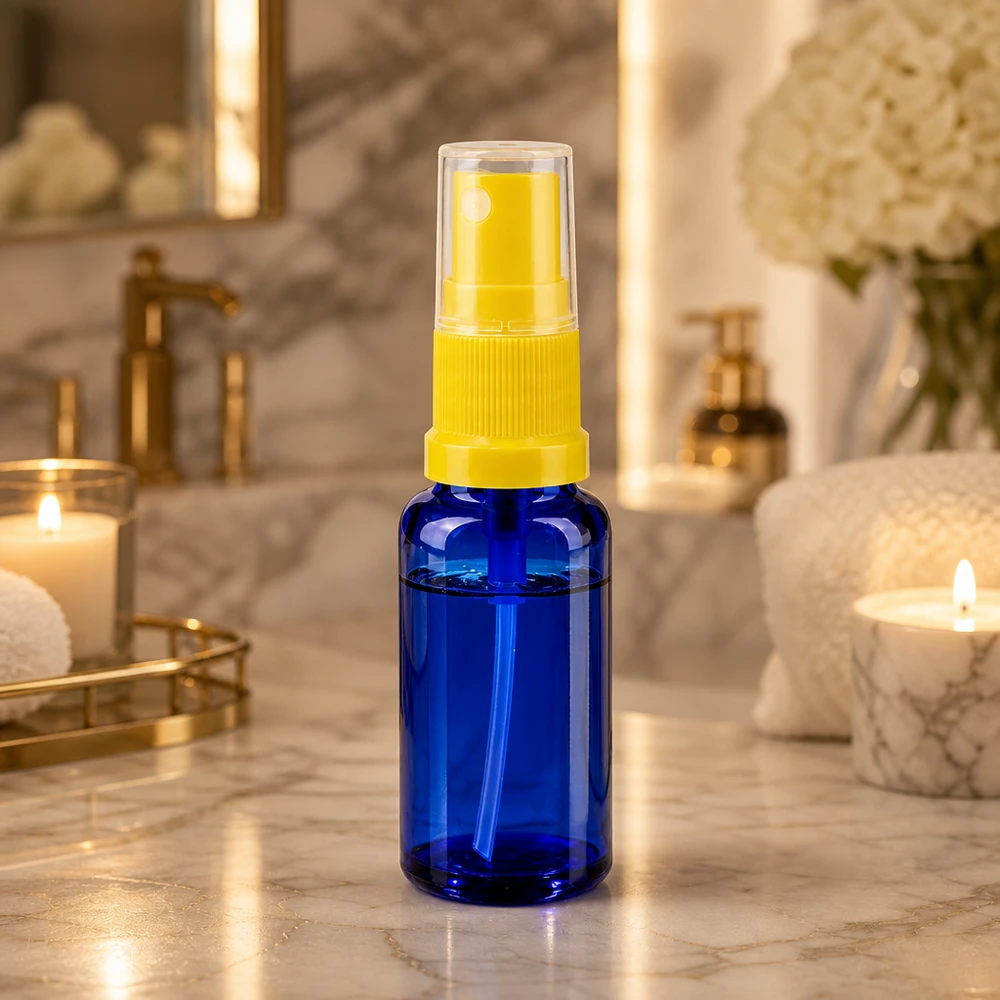 Ronde glazen fles van 20 ml in blauw met een gele pomp voor op reis en om te bewaren