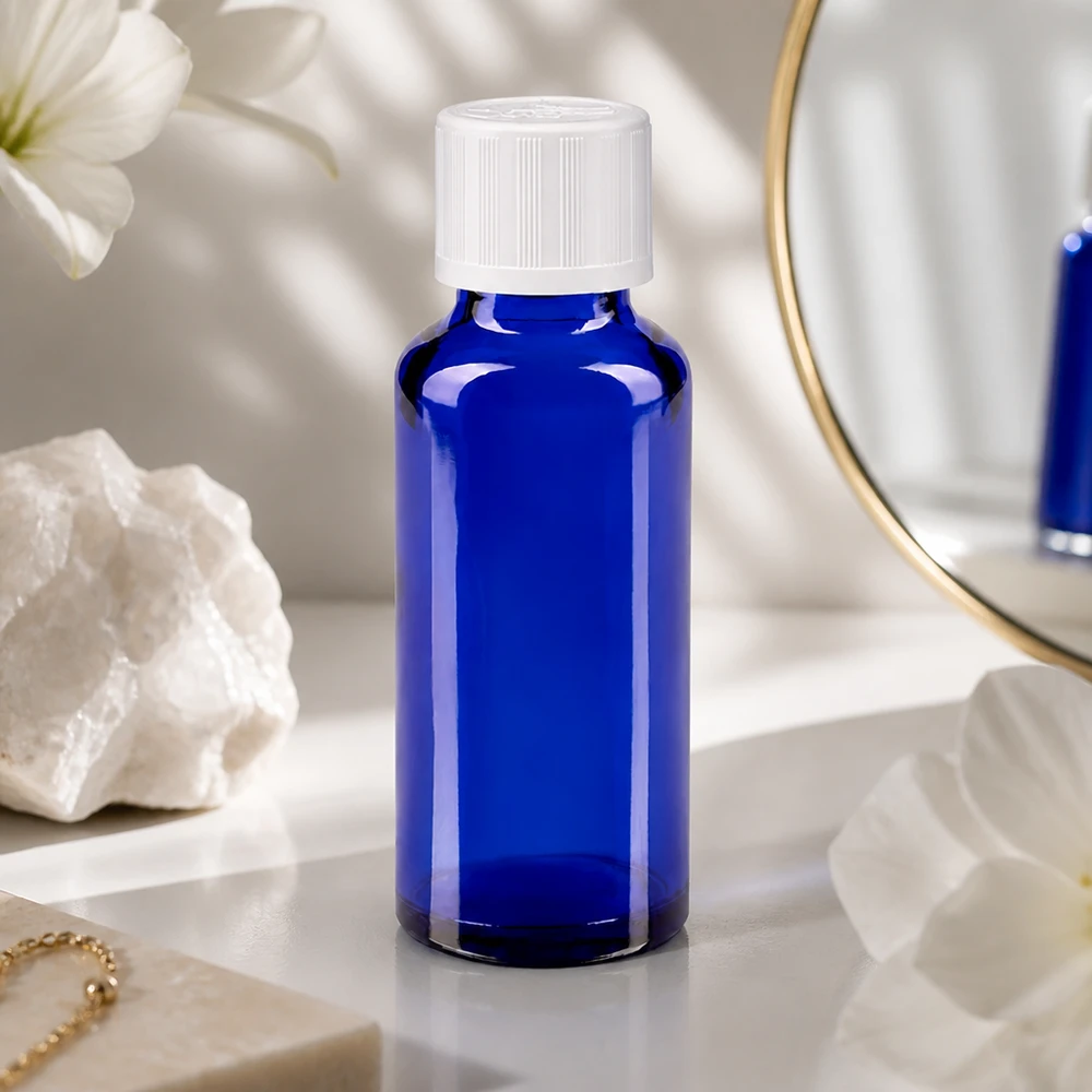 Kobaltblauw flesje van 30 ml met een witte Kindersi-sluiting in een elegante lifestyle-omgeving met spiegel