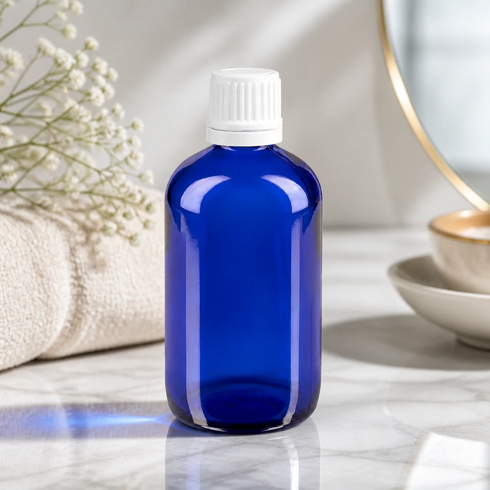Blauwe glazen flessen 100ml met wit schroefsluiting VR Blauwe apothekersfles met UV-bescherming van 100 ml met een witte schroefdop, naast een gouden spiegel en gipskruid
