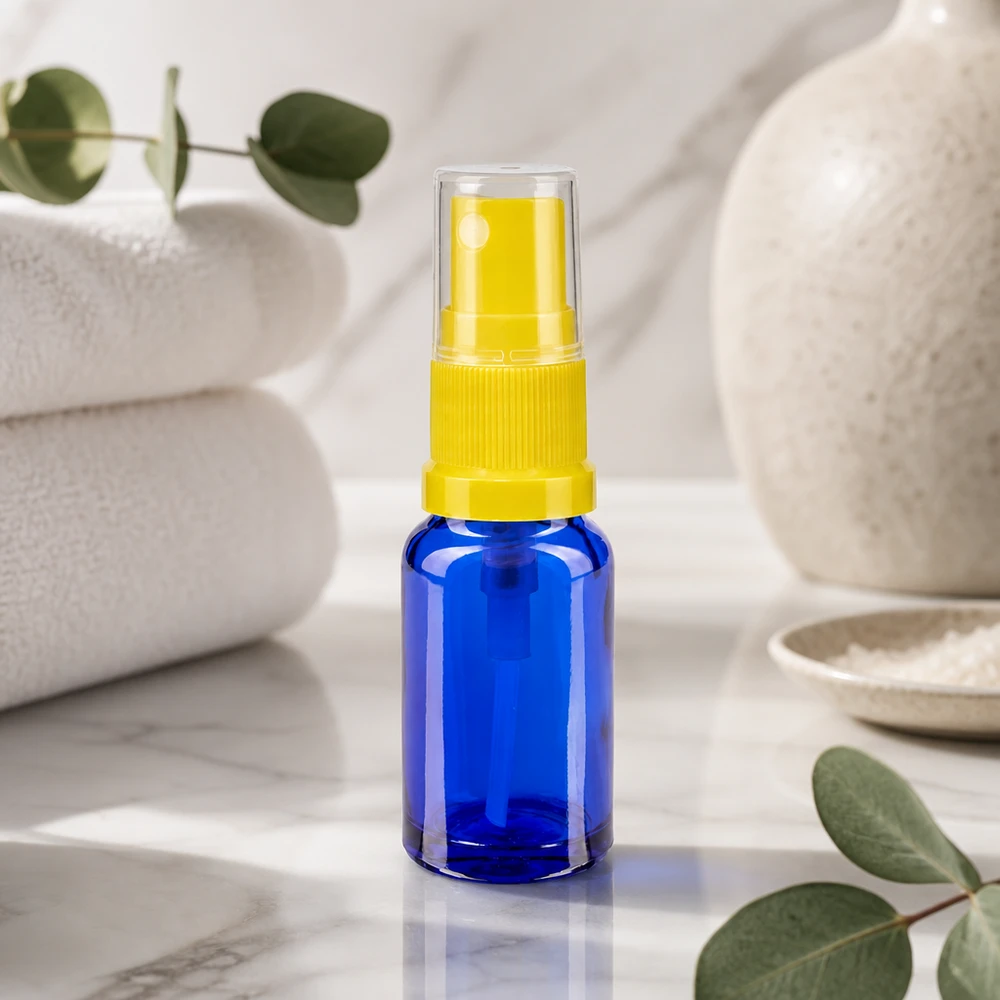 Herbruikbare doseerfles van 30 ml van blauw glas met een gele fijne verstuiver voor apotheken en cosmetica