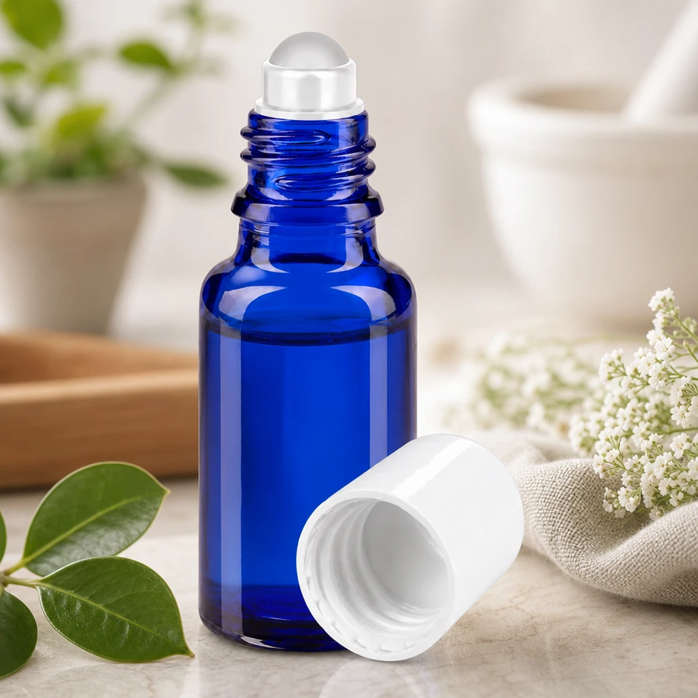 Blauwe glazen fles met roll-on-applicator van 20 ml en een witte dop, met daarachter een vijzel en een stamper