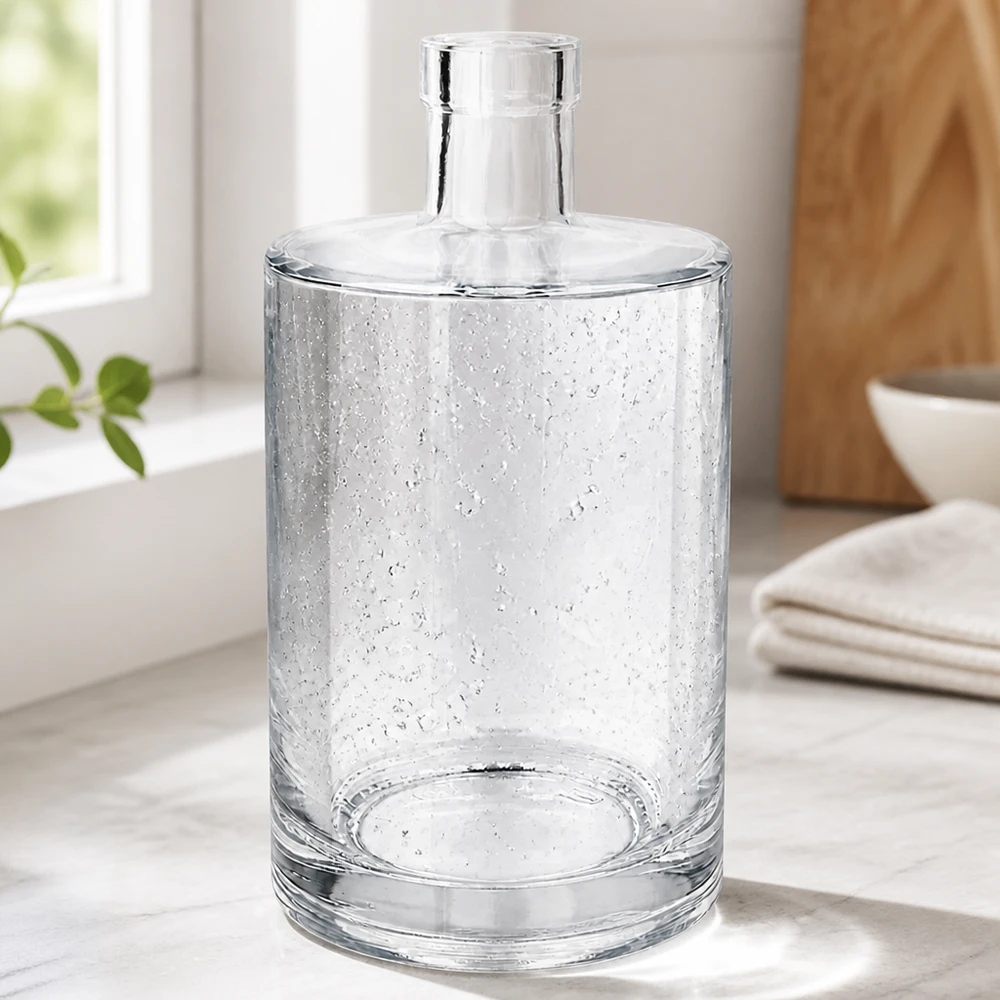 700 ml glazen fles Marie zonder sluiting UNiTWIST® Elegante 700ml Glasflasche Marie mit Luftbläschen-Optik in modernem Wohnambiente neben Handtüchern und Holzschale