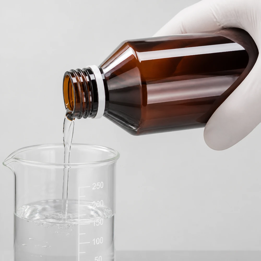 Lichtbestendige fles van 100 ml, bruin PET, bij het nauwkeurig vullen van een laboratoriumbeker van 250 ml