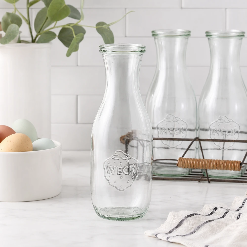 WECK sapfles 1062ml glazen fles leeg in moderne witte keuken met eierschaal draadmand en plant
