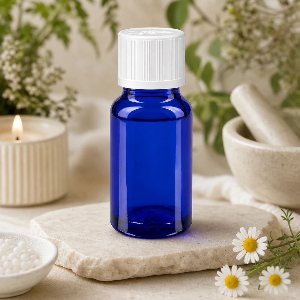 Blauwe glazen flessen 10ml met wit sluiting KiSi St Blauw apothekersflesje van 10 ml met witte schroefdop op marmer, naast geneeskrachtige kruiden