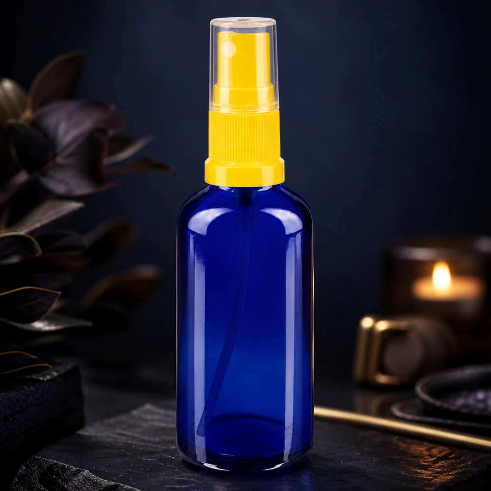 Kobaltblauwe glazen spuitfles van 50 ml met gele pomp in een sfeervolle omgeving
