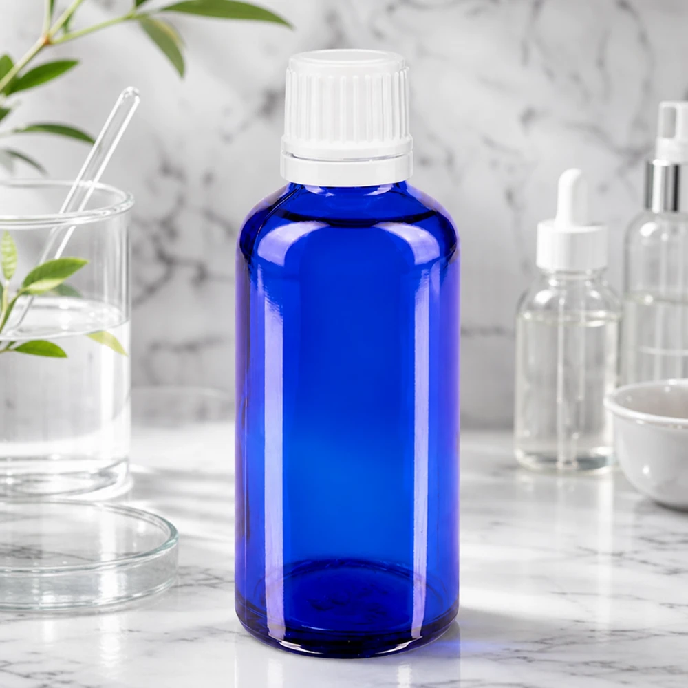 Blauwglazen druppelflesje van 50 ml met witte OV-dop, ideaal voor het bewaren van lichtgevoelige vloeistoffen