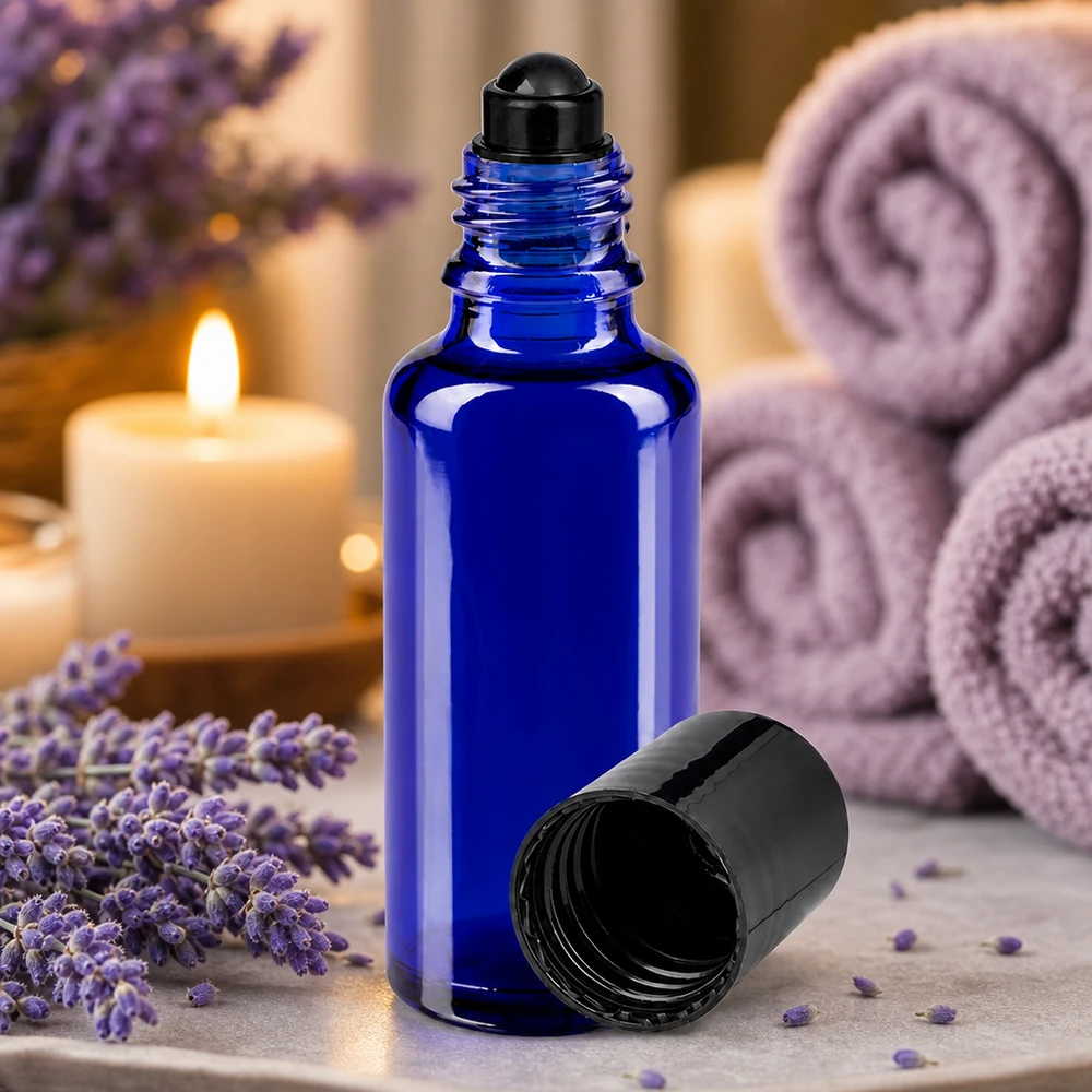 Blauwe ApoGlas-roll-onfles van 30 ml met geopende dop op marmer naast opgevouwen handdoeken