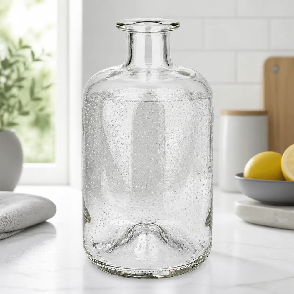 Apothekersfles Luna 500ml met bellenstructuur op een wit keukenblad naast citroenen en planten