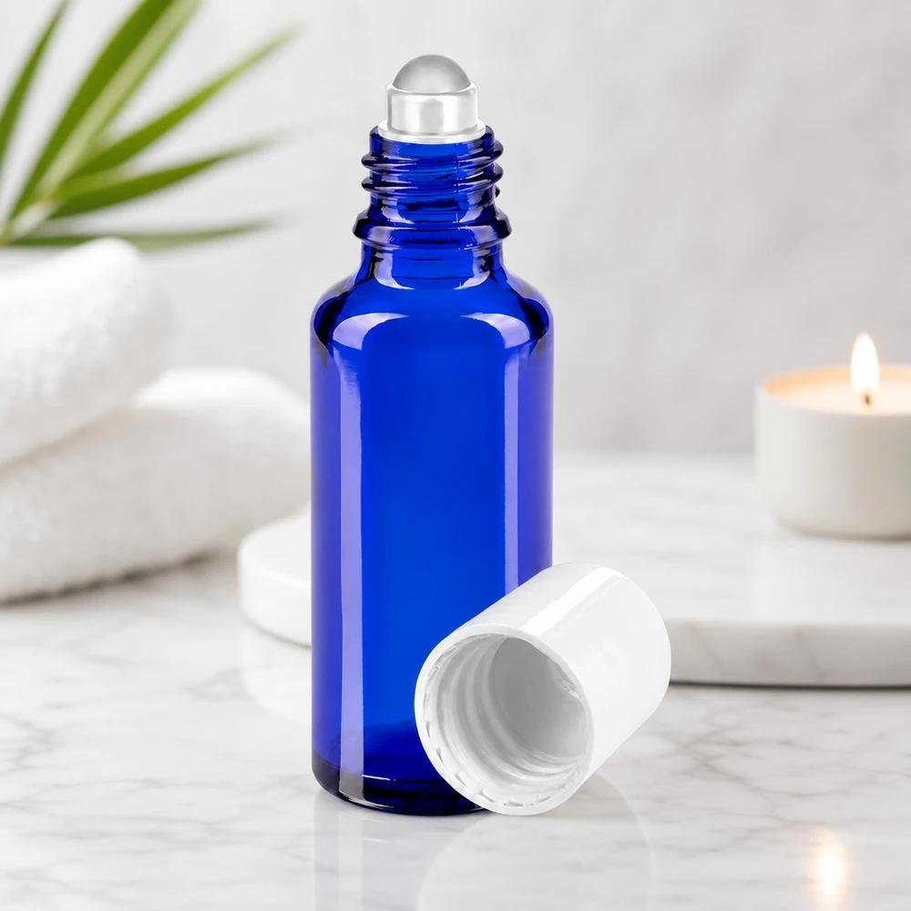 Blauwe glazen rollerflesje van 30 ml STD voor aromatherapie met witte dop op een marmeren achtergrond