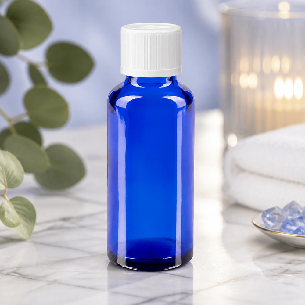 Kleine blauwe glazen fles van 30 ml met een witte kindveilige dop in een rustige spa-sfeer