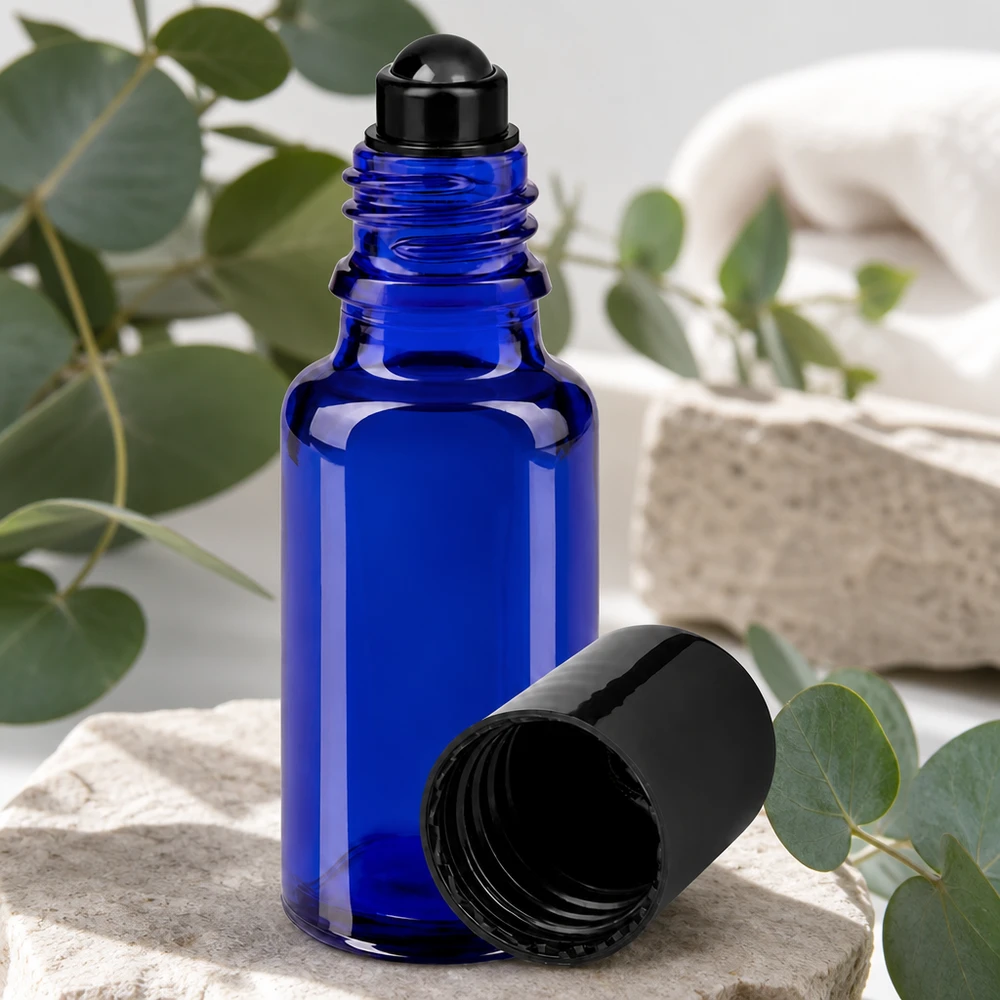Blauw roll-on-flesje van 20 ml van UV-bestendig glas met een zwarte roller op een stenen achtergrond