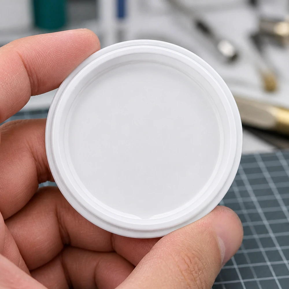 Witte TO63 twist-off-dop BioSeal BPA-NI unitemp, vastgehouden tussen duim en vingers