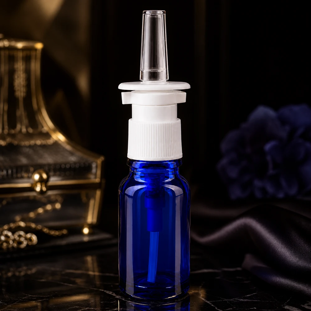 Doorzichtige sproeikop op een kobaltblauw glazen flesje van 10 ml met een geribbelde witte pomp