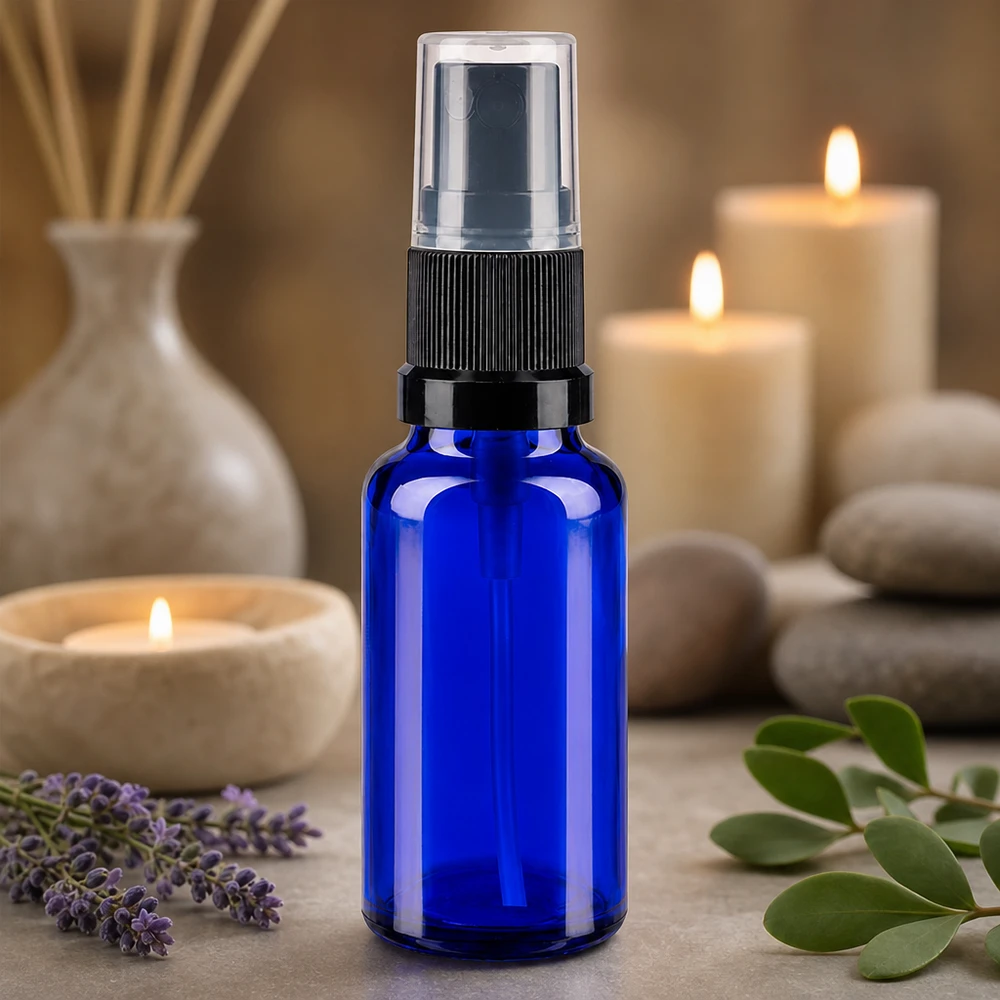 Slanke blauwe glazen spuitfles van 20 ml met zwarte verstuiver, ideaal voor wellnessproducten