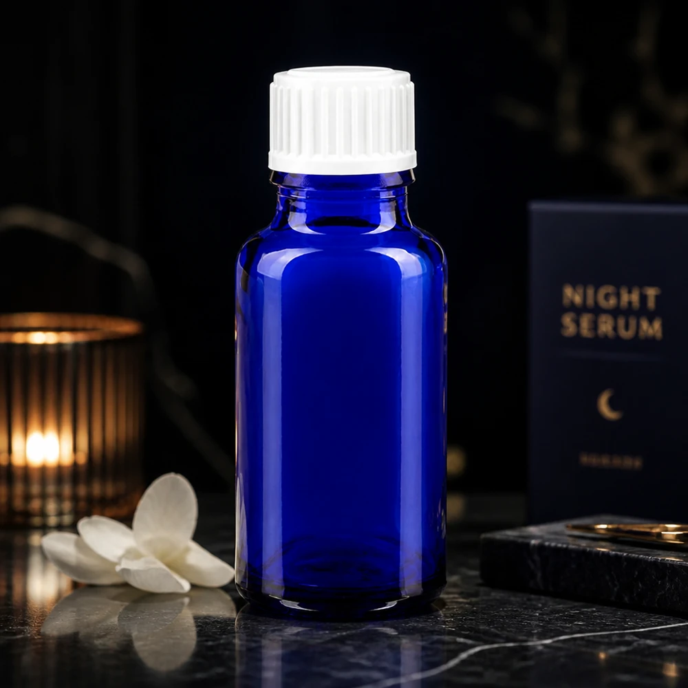 Elegante kobaltblauwe serumfles van 20 ml, van glas, met een witte dop, in een sfeervolle nachtelijke omgeving