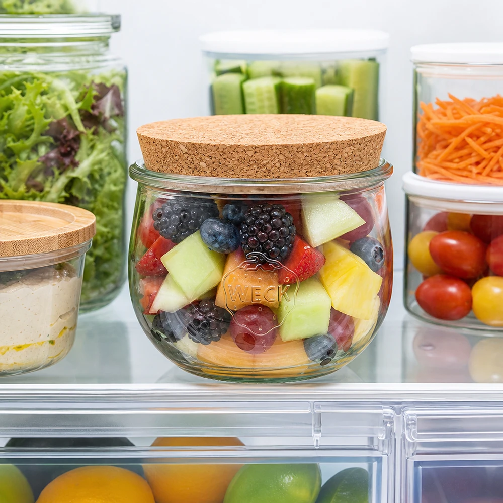 580ml tulpenglas WECK RR100 met kurk WECK tulpenpot 580ml met kurken deksel in de koelkast gevuld met fruitsalade naast andere voorraadpotten met groenten