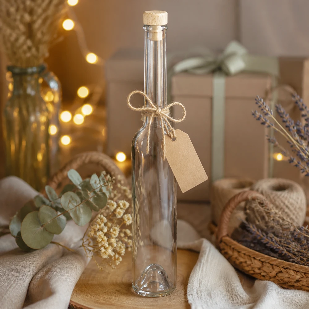 100 ml glazen fles Hugo met houten handgreepkurk UNiTWIST® Hugo glazen fles van 100 ml met kurk en kadolabel in een natuurlijke decoratieve scène met lavendel en feeënlichtjes