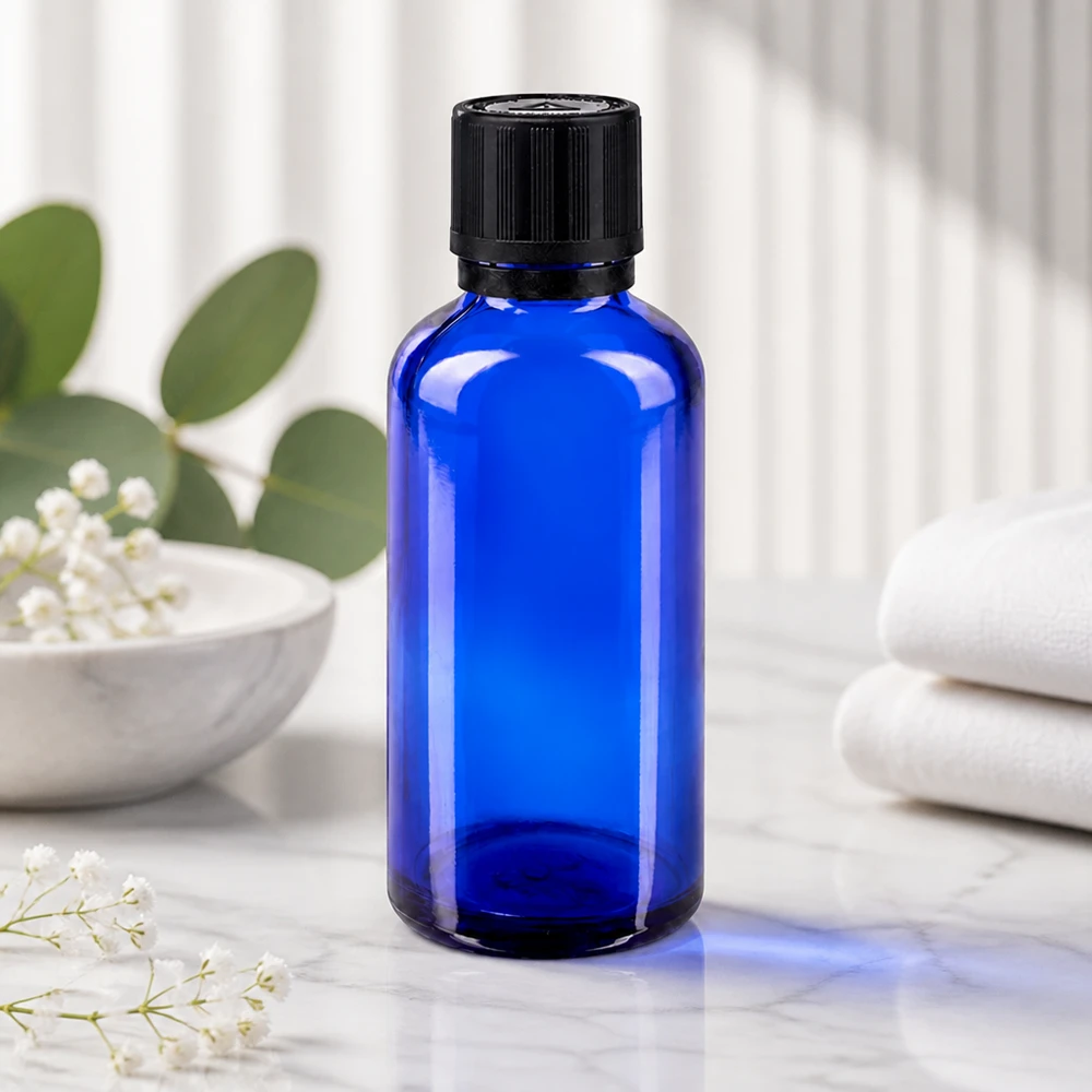 Blauw flesje van 50 ml met UV-beschermend glas en een zwarte OV-sluiting, naast opgevouwen witte handdoeken