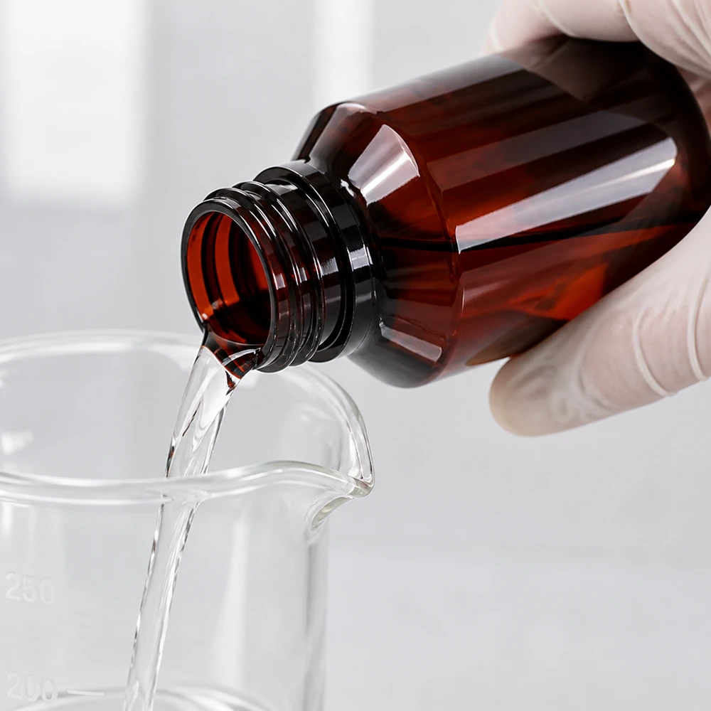 100 ml PET medicijnfles met wit dispenserpomp, standaard Chemikalienbeständige PET Flasche 100ml bernsteinfarben mit weisser Dispenserpumpe in Laborumgebung