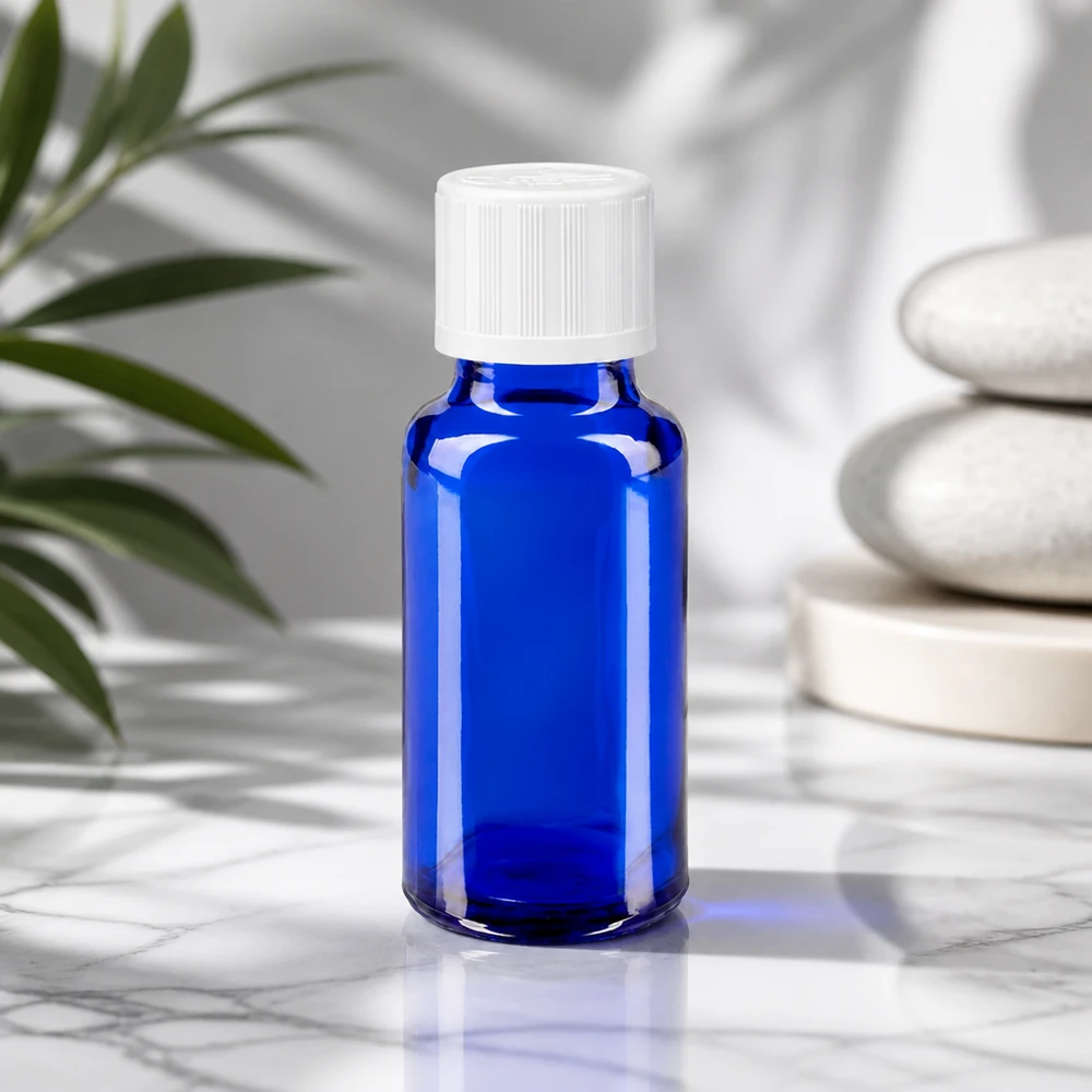 Blauwe glazen flessen 20ml met wit schroefsluiting kinderslot St Blauw gekleurd glazen flesje van 20 ml met een geribbelde witte schroefdop op een marmeren ondergrond