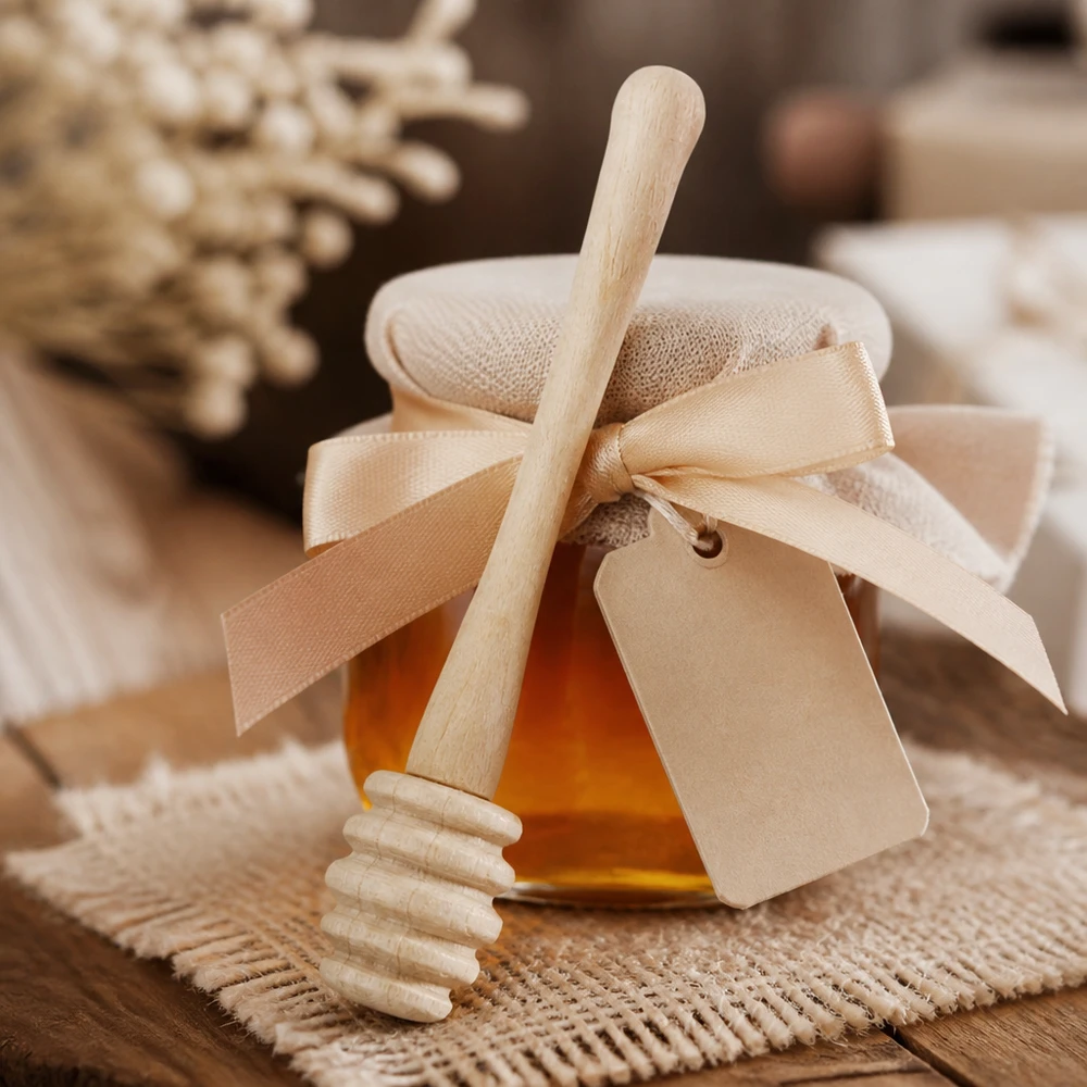 Honinglepel van esdoornhout met geschenkverpakking en lint als geschenk naast honingraten op een jute achtergrond