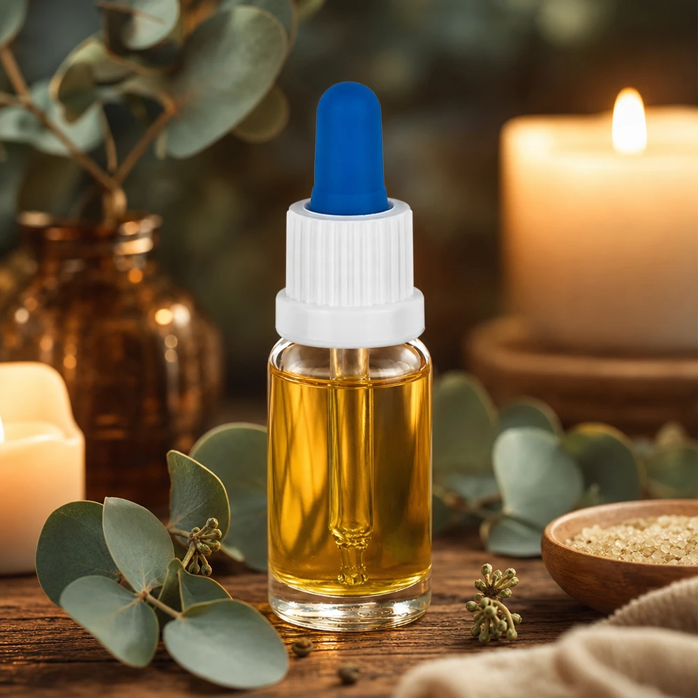 Kleine pipetfles van 10 ml met goudkleurige olie, een witte dop en een blauw rubberen balletje op een houten tafel