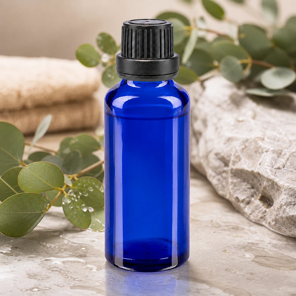 Blauwe glazen flessen 30ml met zwart schroefsluiting dicht. VR Premium Blauwe farmaceutische glazen fles van 30 ml met geribbelde zwarte dop tegen een natuurlijke spa-achtergrond