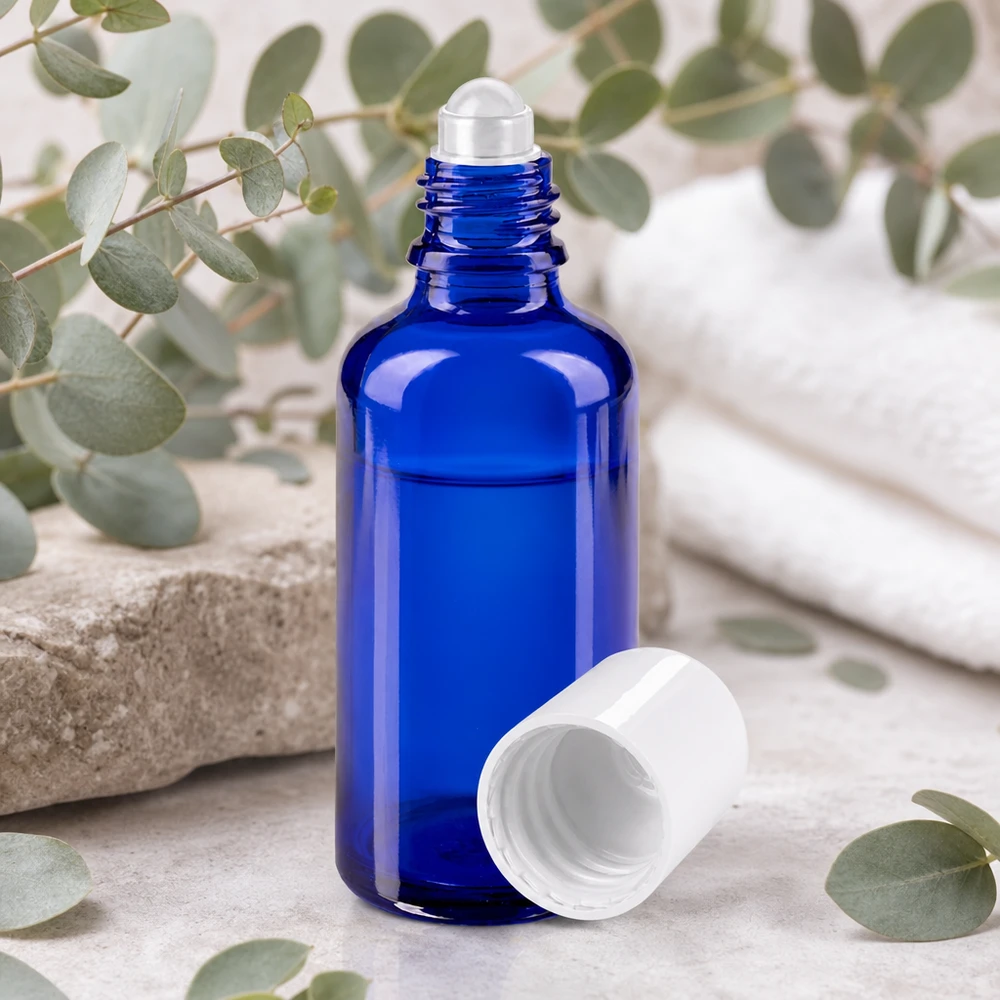 Apothekersflesje blauw 50ml roll-on cap wit Blauwe glazen rollerfles STD van 50 ml met verwijderde witte dop op een lichte marmeren achtergrond