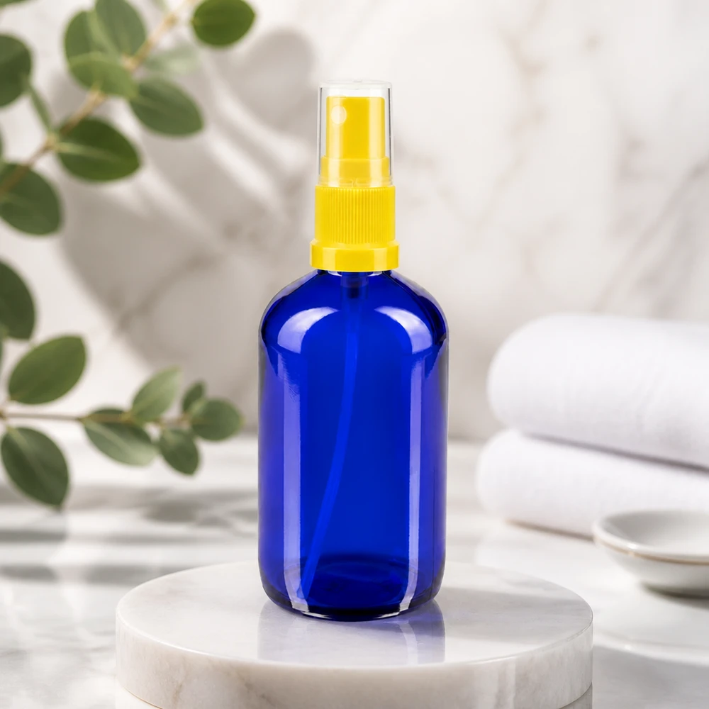 Blauw apothekersglas van 100 ml met een gele fijne-nevelverstuiver voor kamersprays