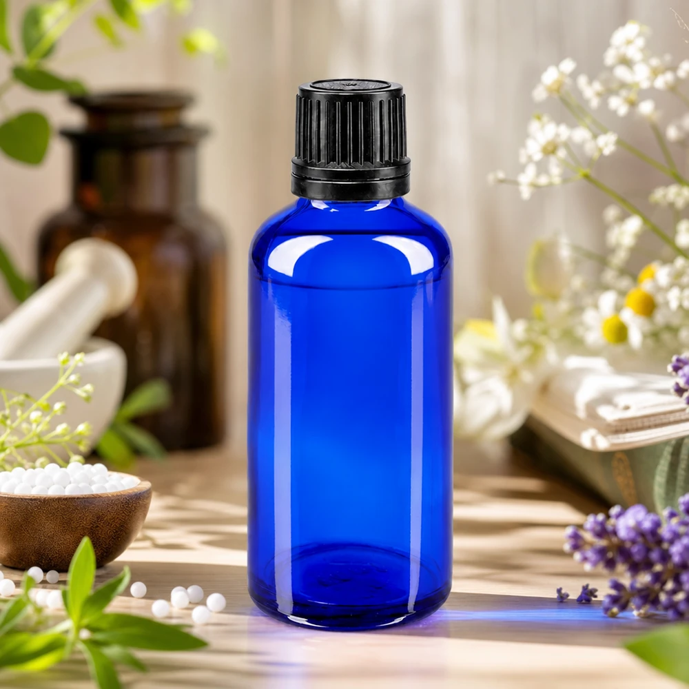 Blauwe druppelfles van 50 ml met zwarte schroefdop in een natuurgeneeskundige omgeving met globuli