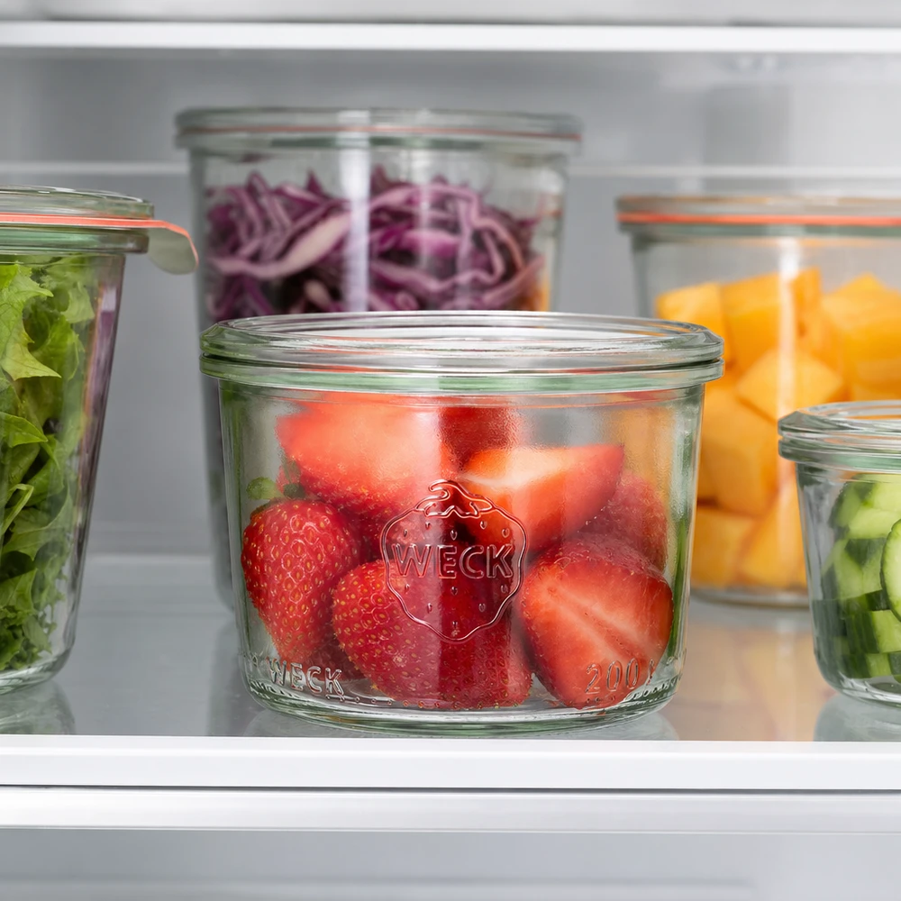 WECK 200 ml RR80 bekers met verse aardbeien in de koelkast naast andere potten gevuld met fruit en groenten