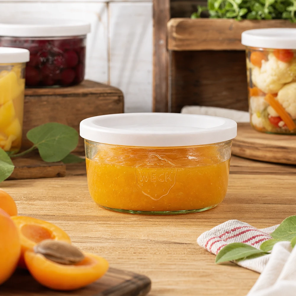 165ml stortglas met vershouddeksel WECK RR80 WECK 165ml mason jar gevuld met sinaasappeljam in een natuurlijke keukenomgeving met inmaakpotten op de achtergrond