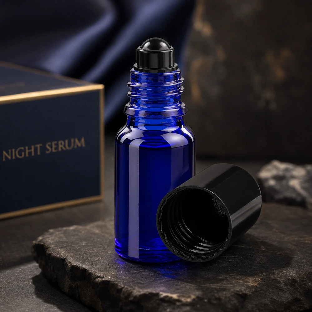 Blauw roll-on-flesje van 10 ml van ApoGlas met zwarte roll-on-dop op een leisteenplaat: een elegante productpresentatie