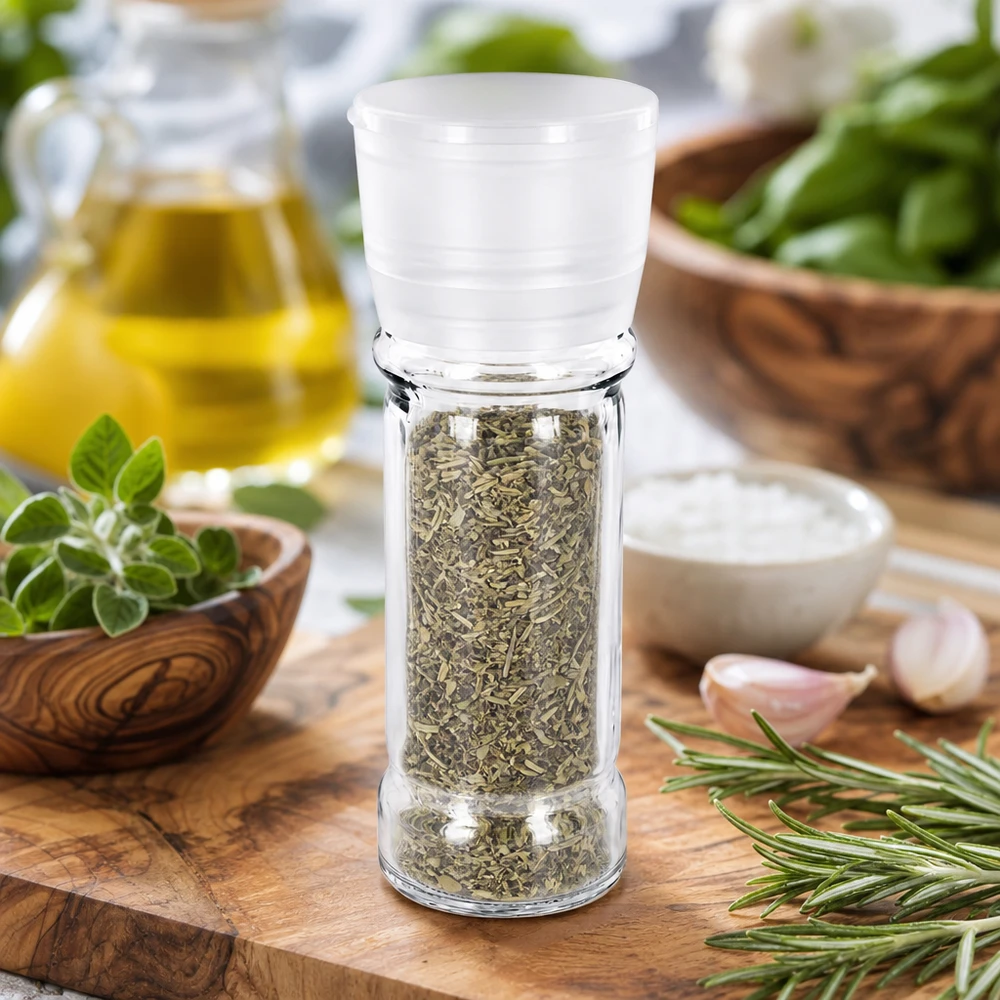 Zout-/kruidenpotje 100 ml met molen Vario wit Zoutmolen van 100 ml van helder glas met een witte maalkop, tussen mediterrane ingrediënten en basilicum