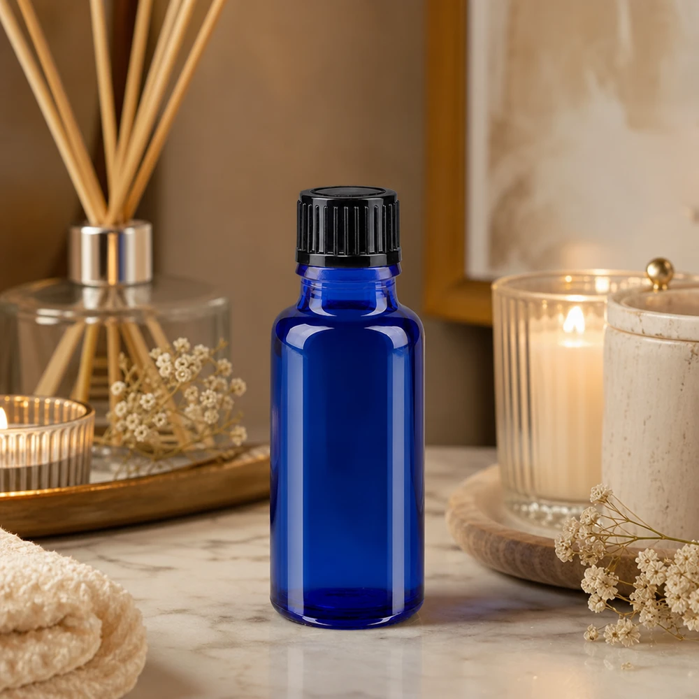 Blauwe glazen flessen 20ml met zwart schroefsluiting St Kleine blauwe medicijnflesje van 20 ml met zwarte dop in een marmeren wellness-sfeer